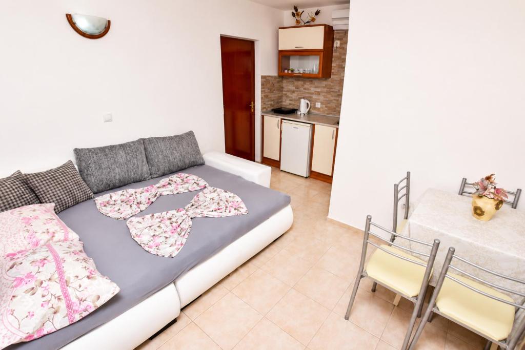 a bedroom with a bed and a table and a kitchen at Vila Mia in Donji Štoj