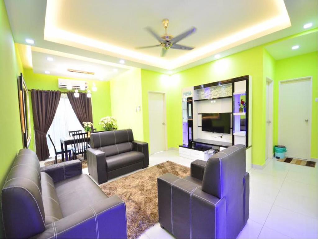 a living room with couches and a flat screen tv at Johar Jantan Apartment in Shah Alam