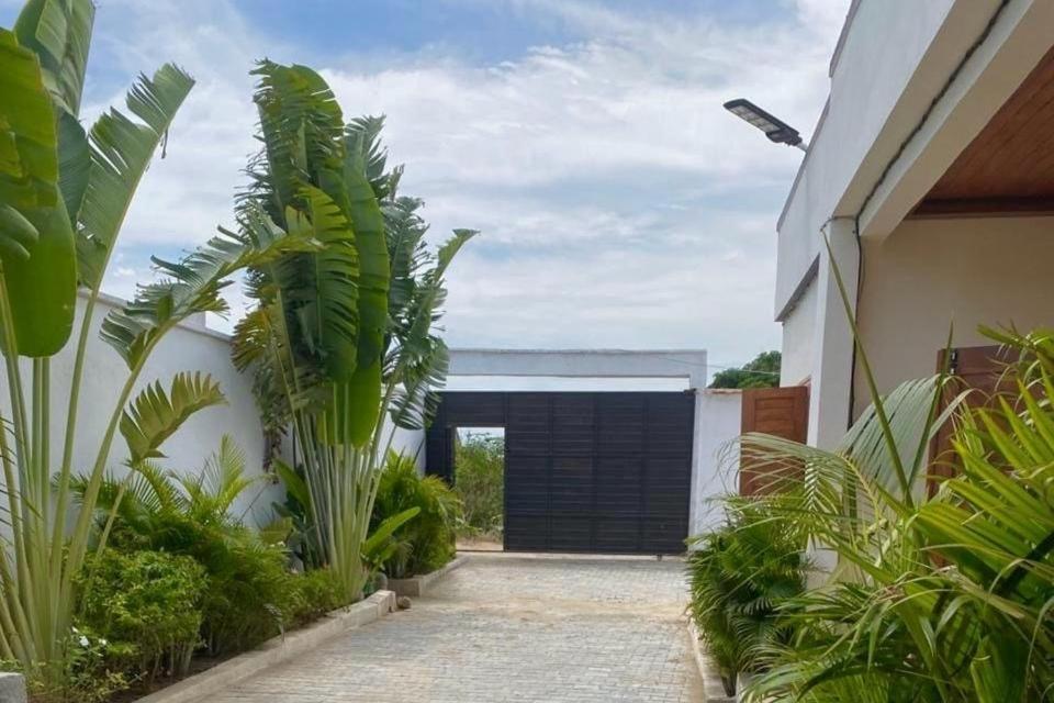 a garage with a black garage door and some plants at Villa REEL in Morondava