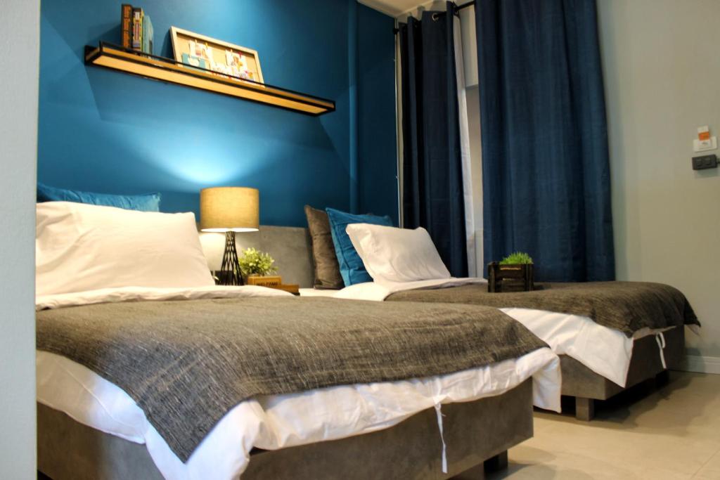 two beds in a room with blue walls at Ku at sea in Ko Samed