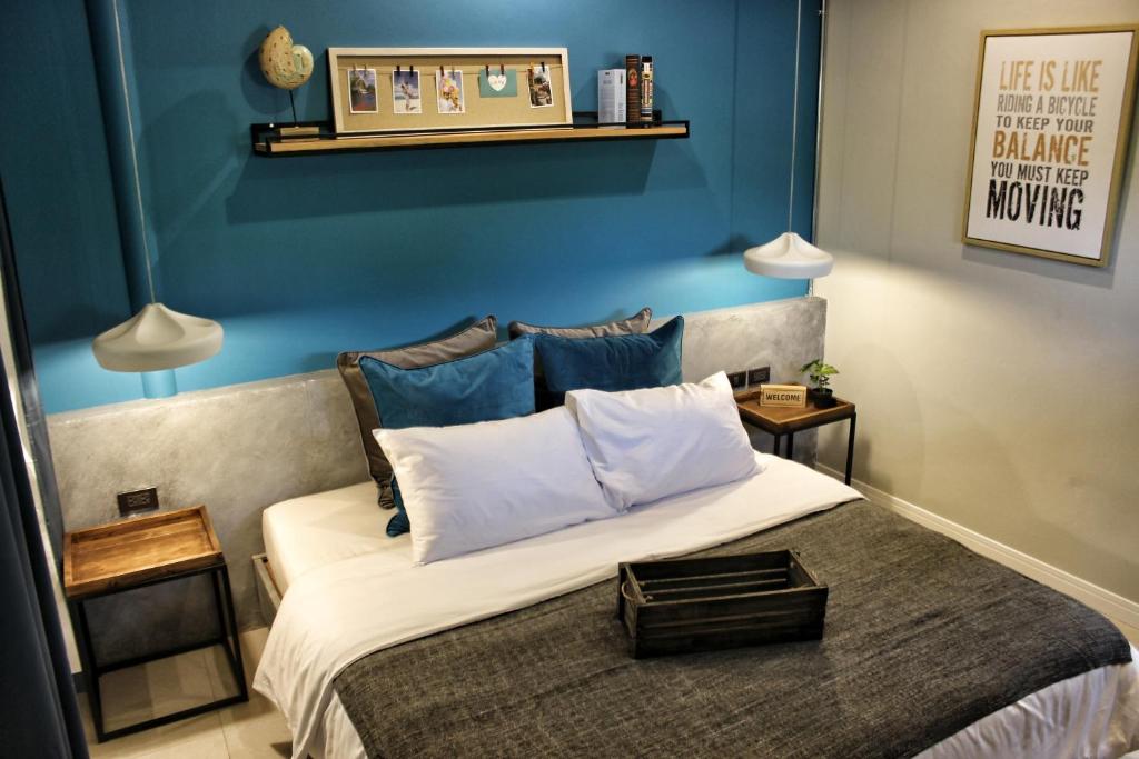a bedroom with a large bed with blue walls at Ku at sea in Ko Samed