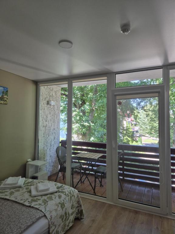 a bedroom with a bed and a balcony with a table at Sunrise Apartments 9 in Juodkrantė