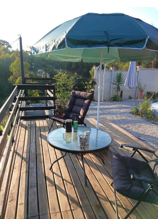 a patio with a table and chairs and an umbrella at Casa com piscina aquecida, estilosa e privativa in Nazaré Paulista