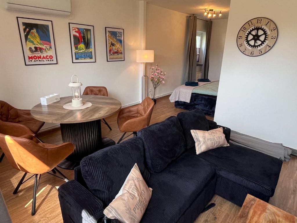 a living room with a blue couch and a table at Appartement zum Grünen Bär klimatisiert in Holzminden