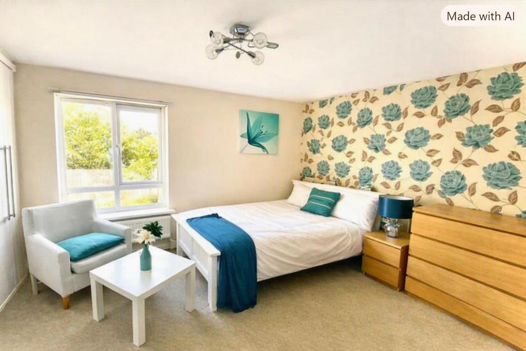 a bedroom with a bed and a chair and a window at The Rosewood in Grays Thurrock