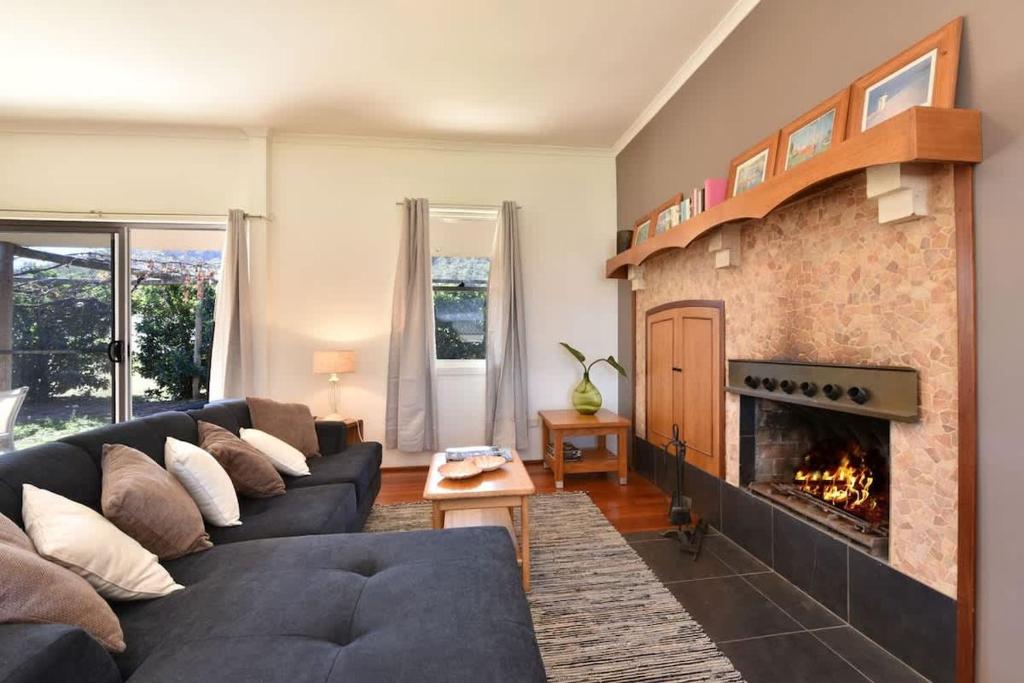 a living room with a couch and a fireplace at Somerville Wine Cottage Hideaway 3-Bedroom Cottage Near Broke Wineries in Broke