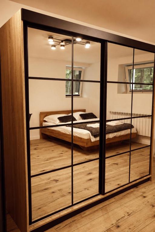 a bedroom with a bed inside of a glass wall at Apartament w Parku 2 in Żywiec