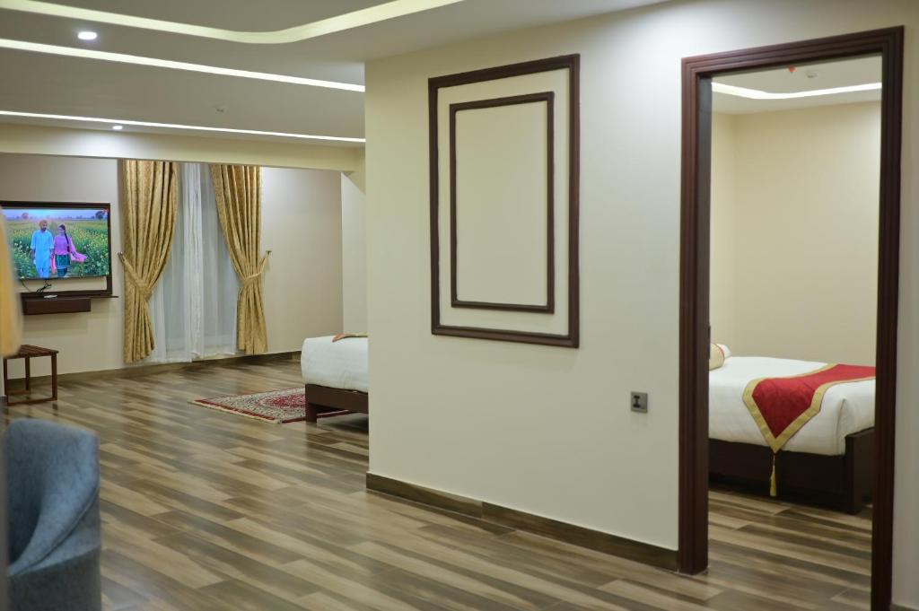 a room with a mirror and a bed and a tv at Dubai Palace Hotel in Sambriāl