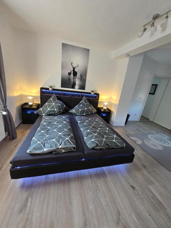 a bedroom with a black bed with two pillows at Buchenau an der Lahn 