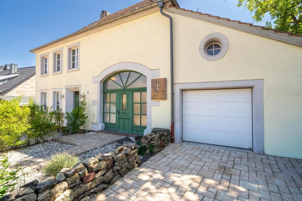 a house with a green door and a stone driveway at Erasmus WaldBlick Ferienhaus mit Ausblick in Saarburg