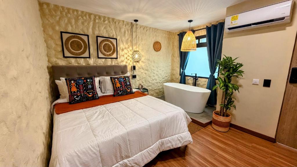 a bedroom with a bed and a bath tub at Nam Hotel Boutique Medellin in Medellín