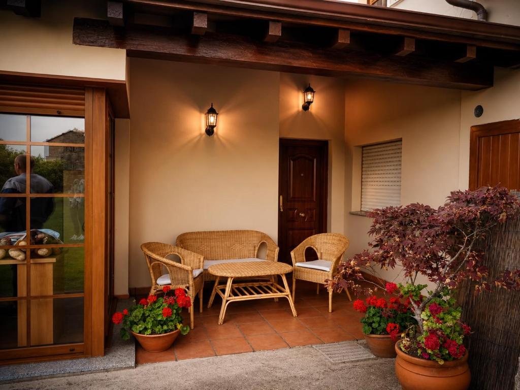 a patio with chairs and a table and some flowers at El Rincón de Luarca in Luarca