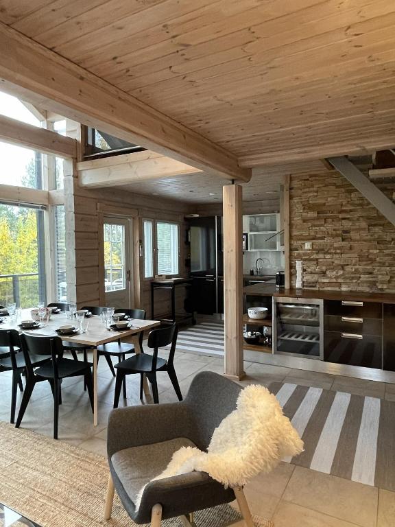 a kitchen and dining room with a table and chairs at Villa Loiste Himos Chalet with Hot Tub in Jämsä