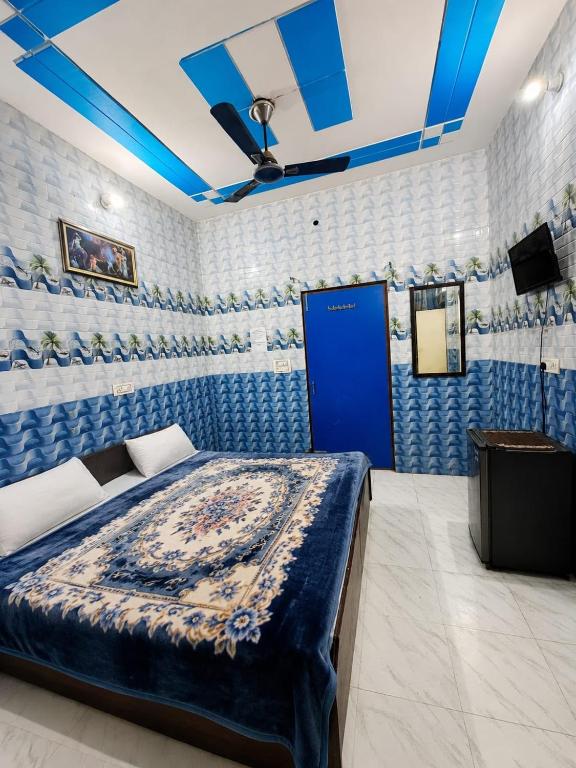 a bedroom with a bed and a blue door at crown house in Phagwāra