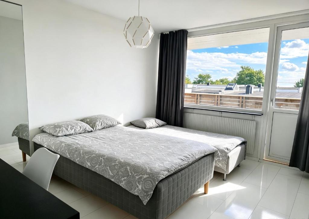 a bedroom with two beds and a large window at Villan Lyan in Lund