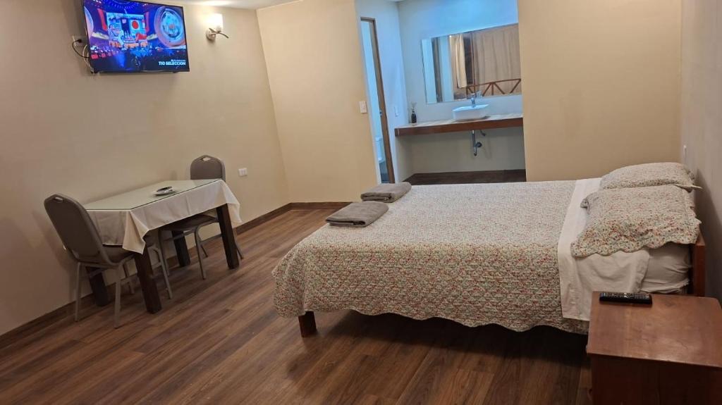 a bedroom with a bed and a table and a television at Pucayacu Wasi in Sauce