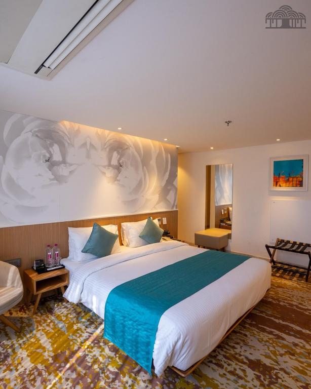a bedroom with a large bed with a blue blanket at The Atlantiis Suites Nr Vishwanath Temple in Varanasi
