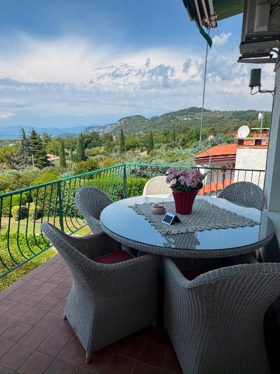 a patio with a table and chairs on a balcony at Viola Apartment Monte Felice in Bardolino