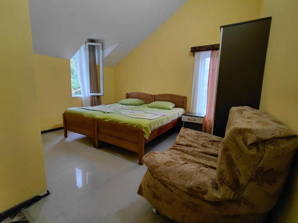 a bedroom with a bed and a chair in it at Guest House Machaxela in Gonio