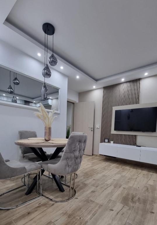 a dining room with a table and chairs and a tv at Apartman Ivkovic in Sremska Mitrovica