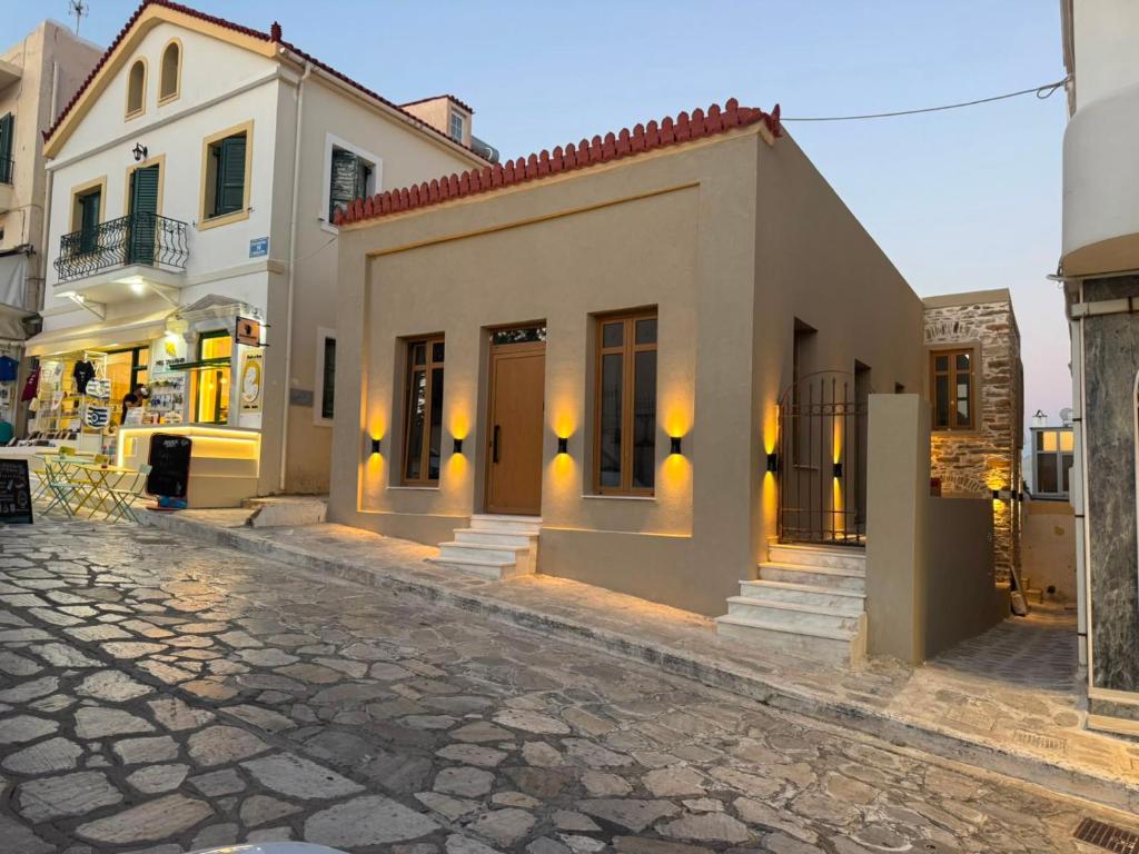 a building on a cobblestone street in a city at Divine Suites Tinos in Tinos
