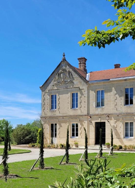 an old stone mansion with a grassy yard at Château Bernon Gite 15 Personnes - piscine et SPA in Queyrac