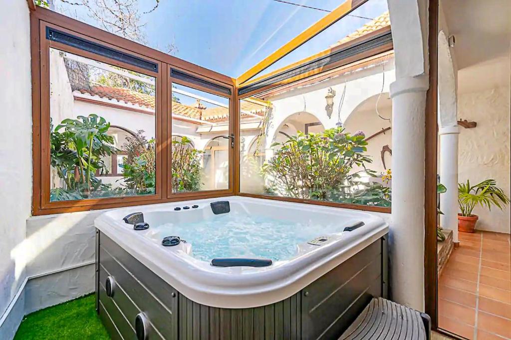 a large bath tub in a room with a large window at Casa Huertas del Palmar in Teror
