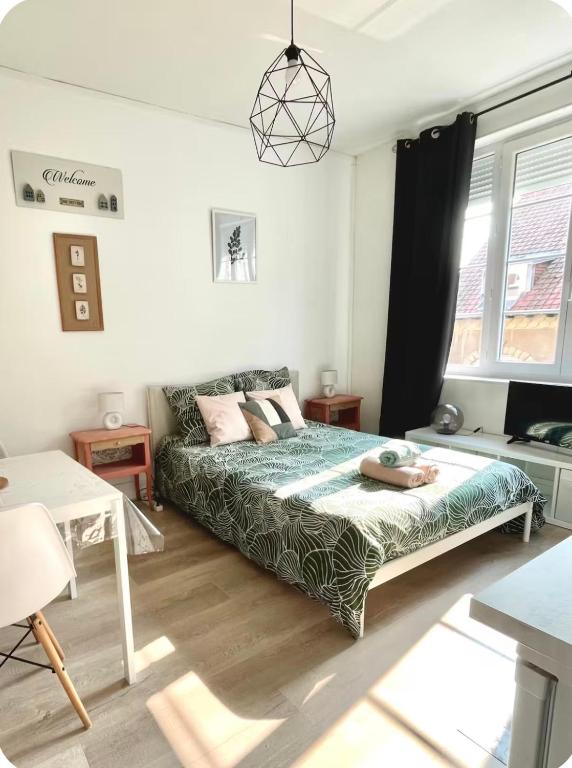a bedroom with a bed and a couch in it at Élégant studio rénové in Boulogne-sur-Mer