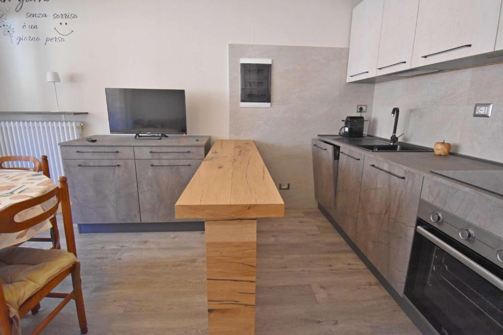 a kitchen with a wooden counter top and a table at MIKI APARTMENT MhD in Madonna di Campiglio