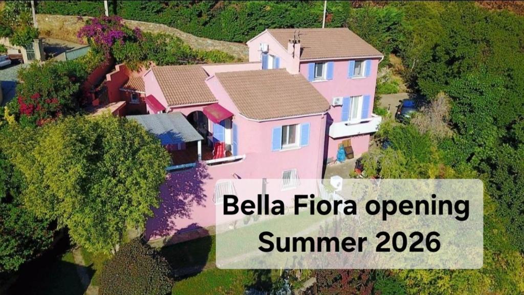 a pink house with a sign that reads bellia loreore opening summer at Chambres d'hôtes Villa bella fiora in Biguglia
