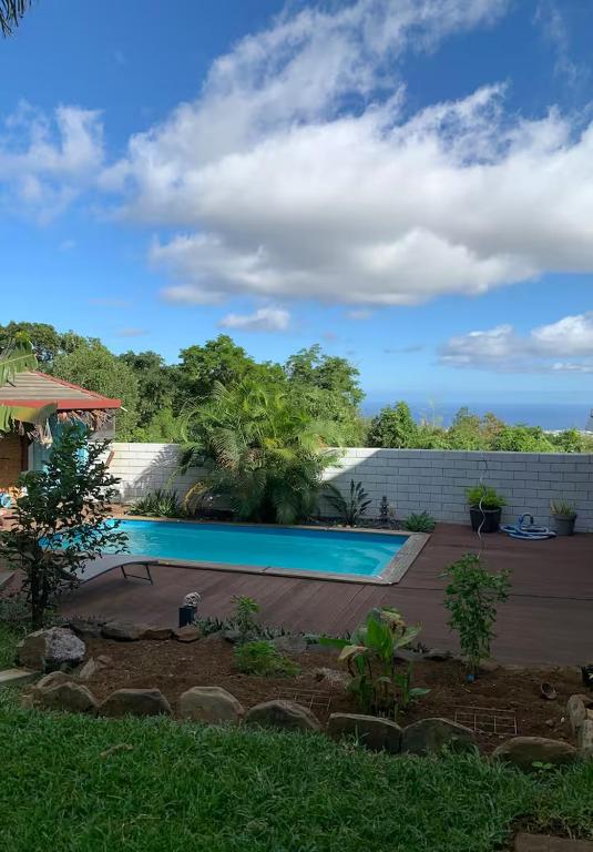 a swimming pool in a yard next to a house at studio P ti koin trankil in La Possession