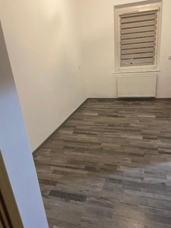 an empty room with a wooden floor and a window at Zatorze in Tczew