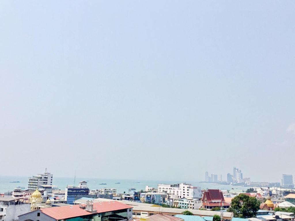 a city with buildings and the ocean in the background at Yensabai Condotel in Pattaya South
