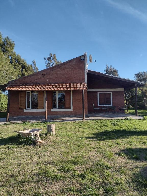 a small house with a bench in front of it at Cabaña Paralelo 1 in Viedma