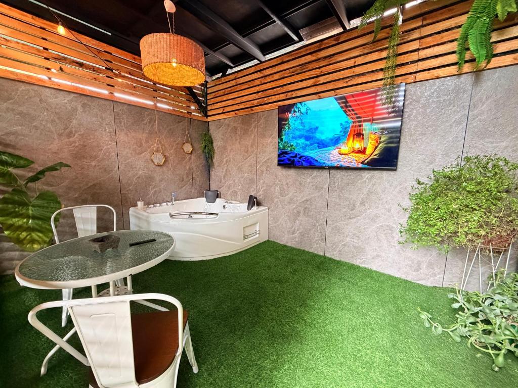 a bathroom with a table and a tv on the wall at Estadía con opción jacuzzi Villa Alemana in Villa Alemana