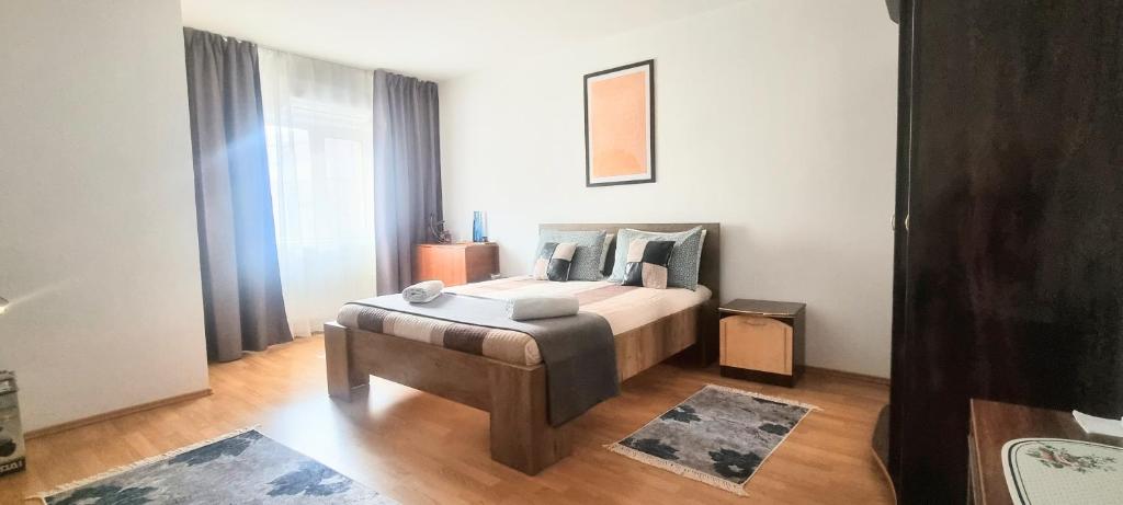 a bedroom with a bed with a wooden floor at Sergio City Apartments in Craiova
