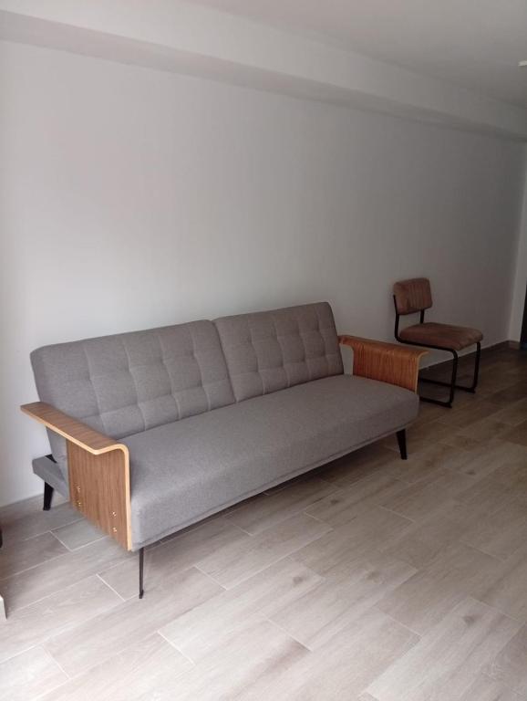 a gray couch in a room with a chair at Carregado Groundfloor in Carregado
