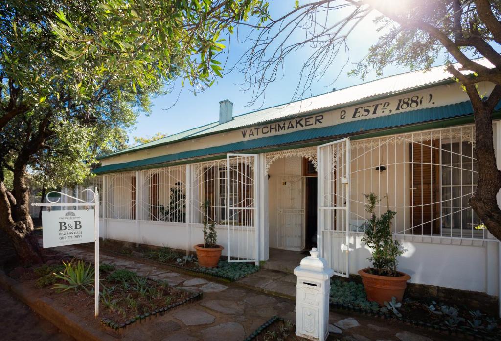 a white building with a sign on the front of it at The Old Watchmakers Guest House in Bethulie