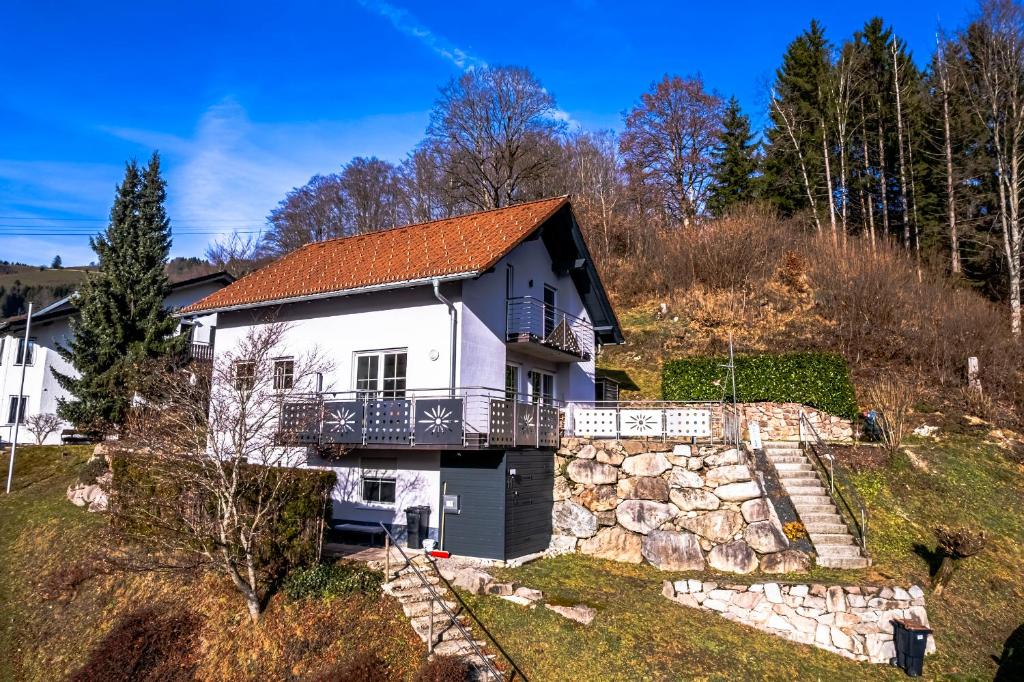 a white house with a balcony on a hill at Ferienwohnung beim Belchen in Wieden