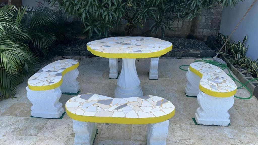 a table and two benches with a table and chairs at The Resident 