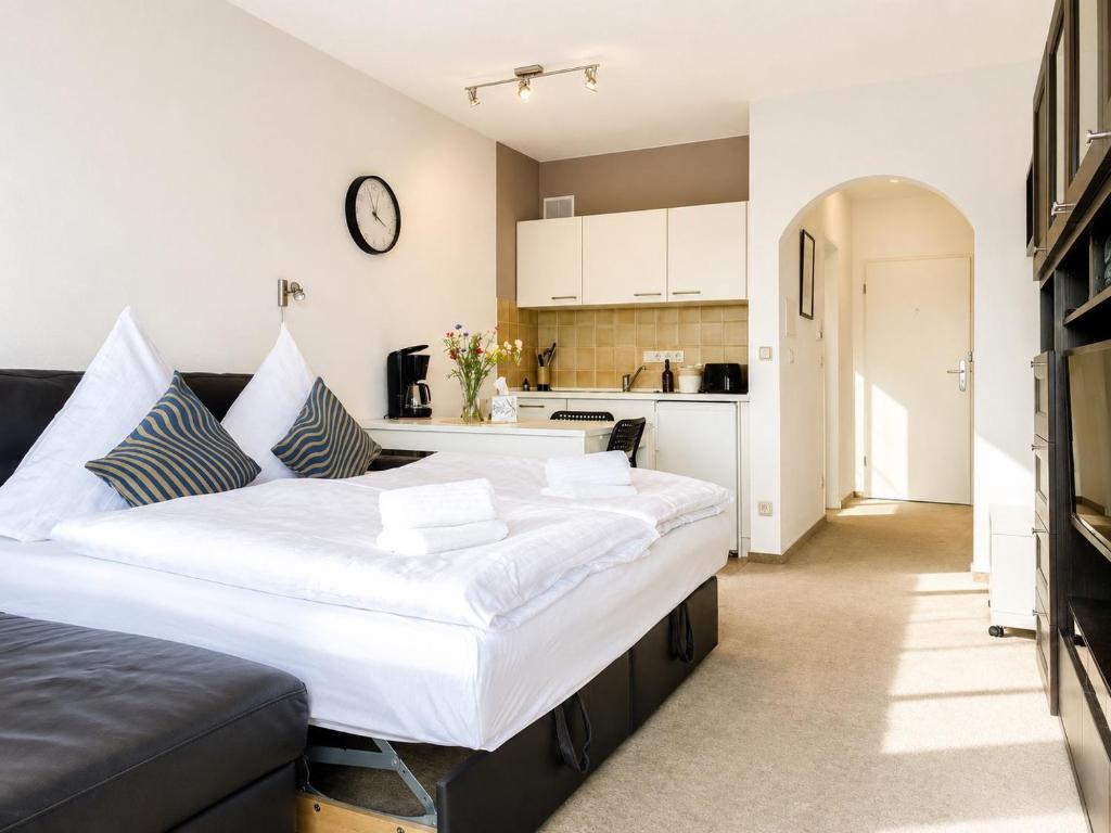 a bedroom with a large bed and a kitchen at Thermenblick in Bad Rodach