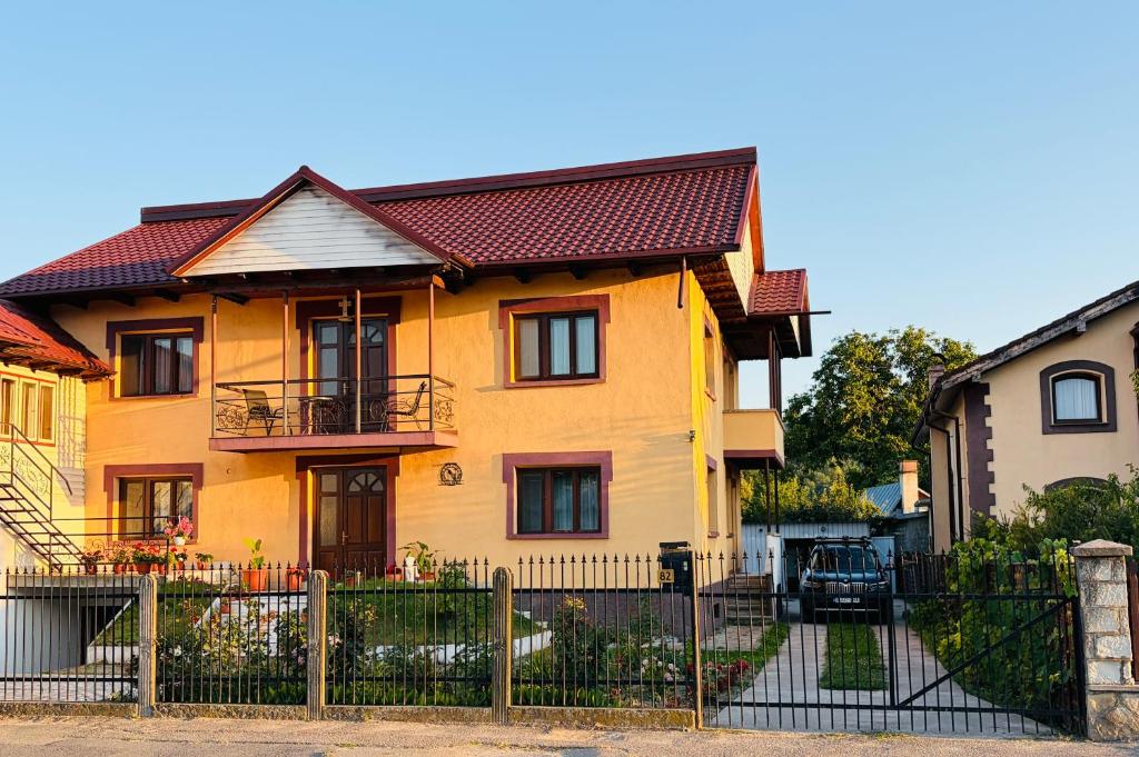 a yellow house with a fence in front of it at Casa Noel in Târgu Ocna