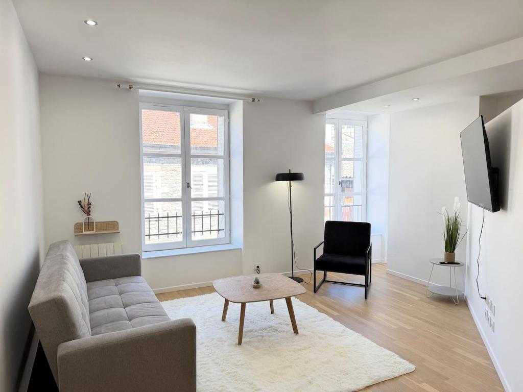 a living room with a couch and a table at Excellence 2 bedrooms in Saint-Pierre-le-Vieux