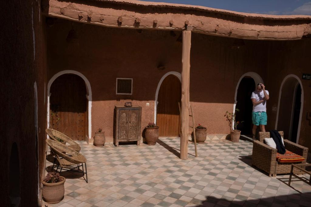 a woman standing on the outside of a building at Tigmi Hamid Découverte des traditions et de la culture berbère in Aït Benhaddou
