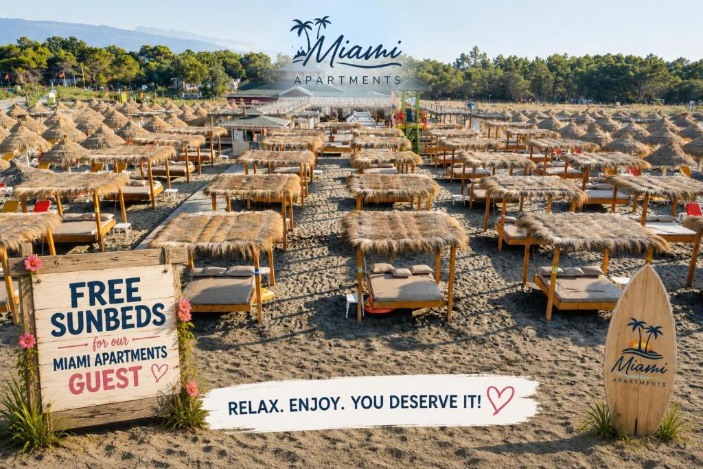 a group of beach chairs and umbrellas on a beach at Miami apartments in Ulcinj