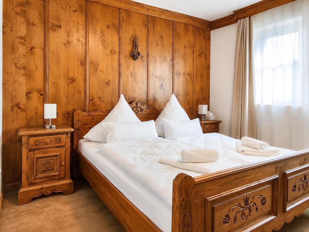 a bedroom with a large bed with wooden walls at Kurpark Suite in Bad Rodach