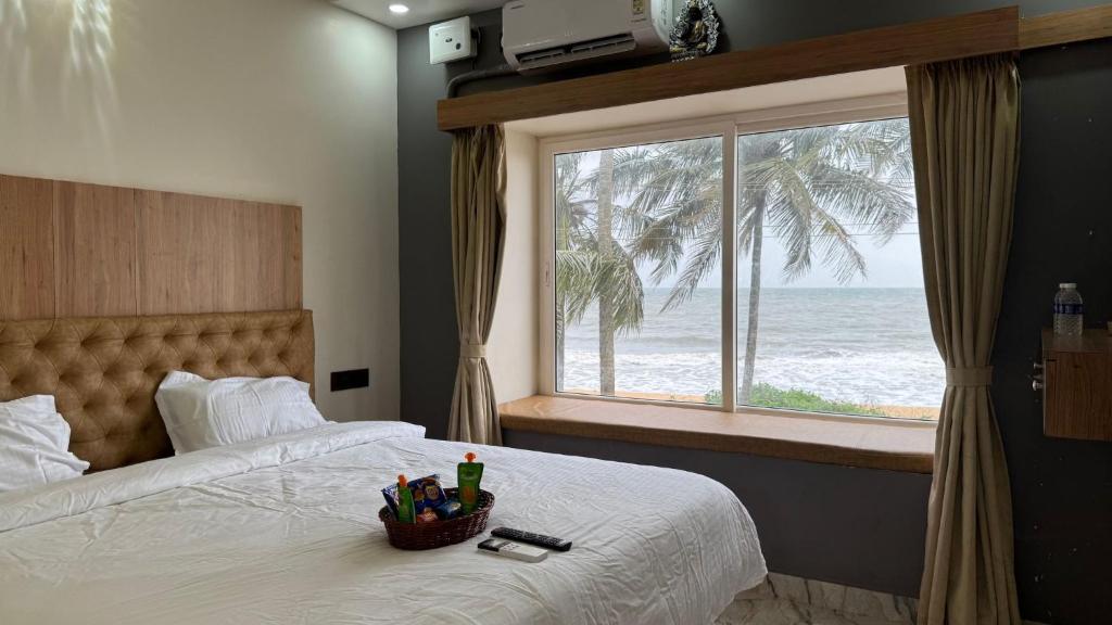 a bedroom with a bed with a view of the ocean at CASANADA Sea View Suite in Malpe