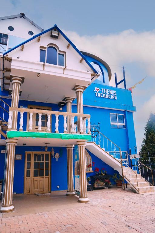 a blue building with a staircase in front of it at Apartamento THEMIS Tocancipa in Bemposta