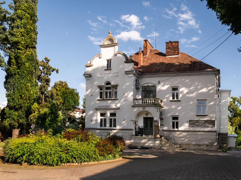 an old white house with a turret at Willa Wiluszówka in Dębica