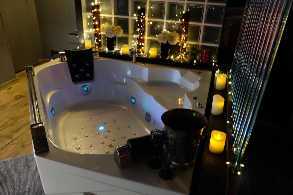 a white bath tub with candles and lights in a bathroom at Lyon Campagne in Rontalon